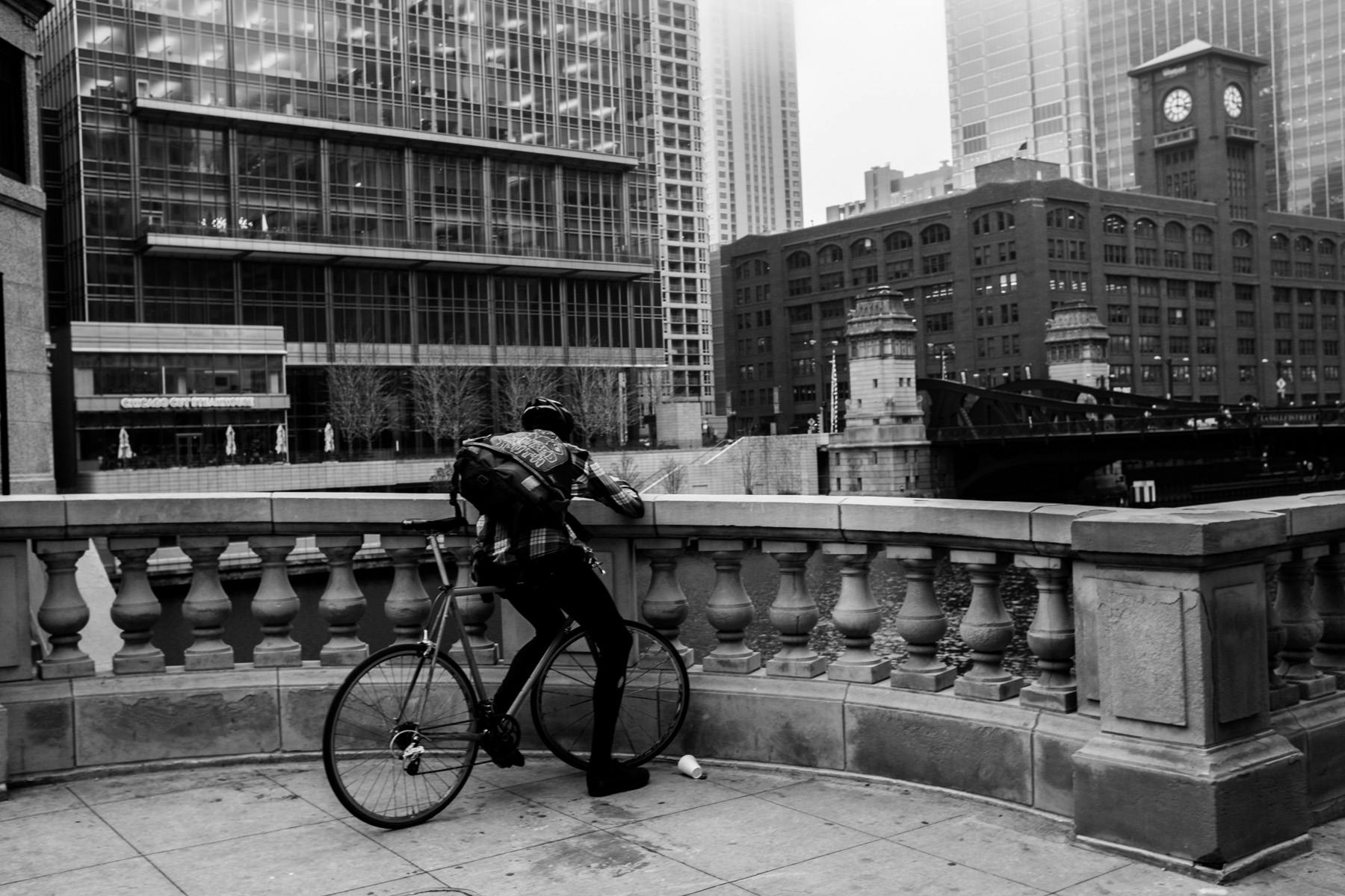 from my bike messenger series. A shot of a messenger sitting at the side of the Chicago river downtown Chicago taking a well deserved break to swipe through social media.