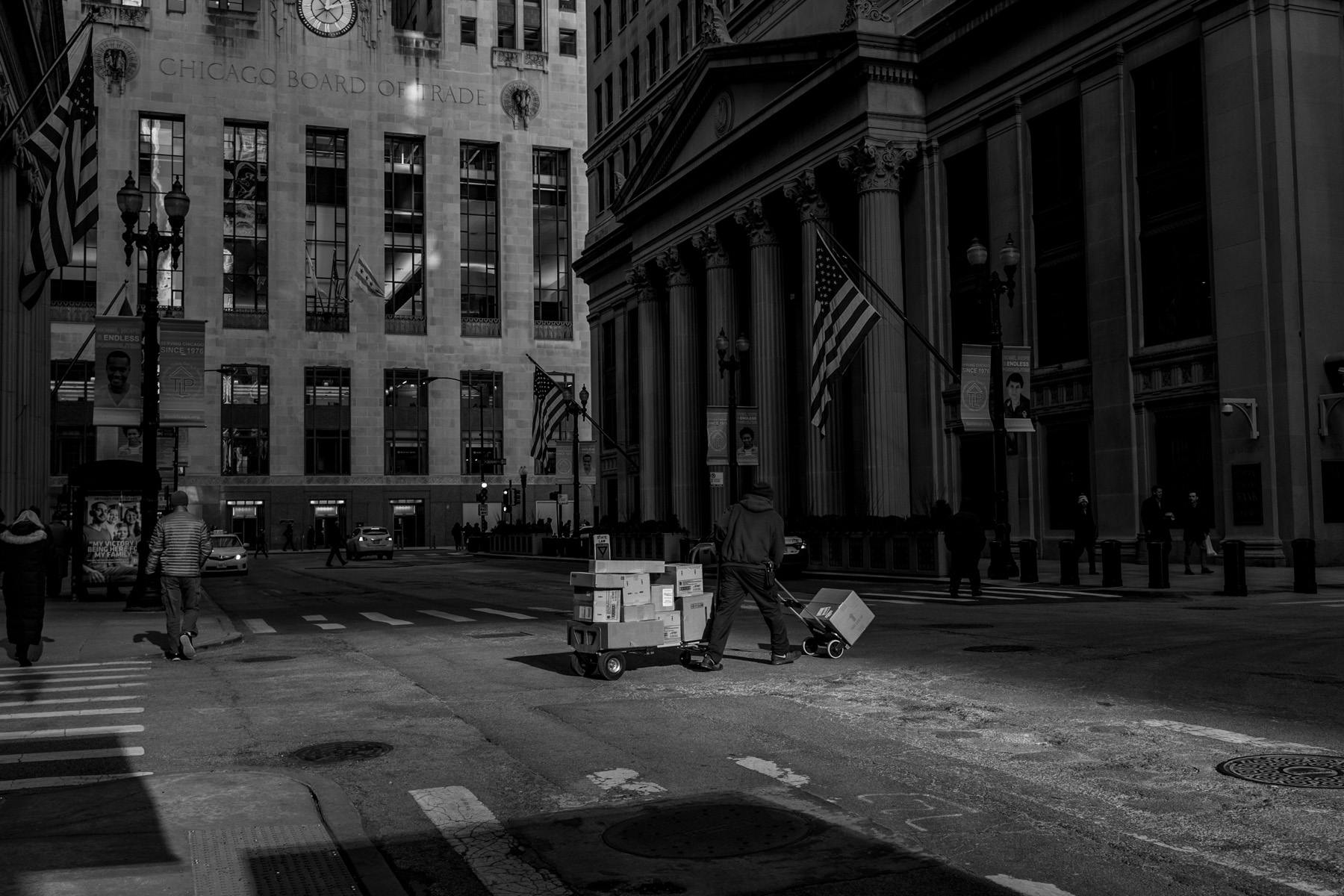 Post delivery man crossing the street in the financial district of Chicago (Black and White)