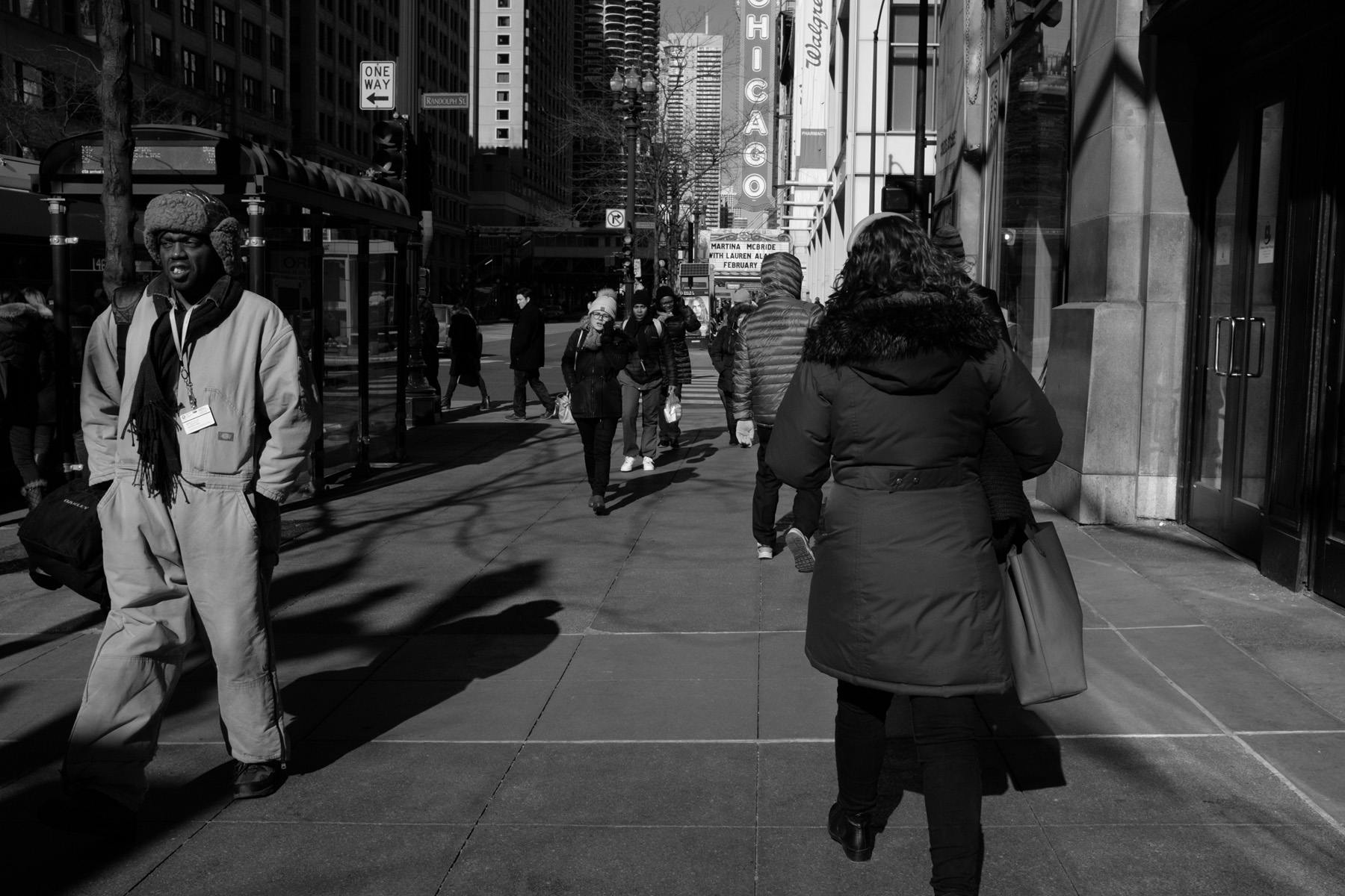 a busy side walk scene in downtown Chicago in winter.
